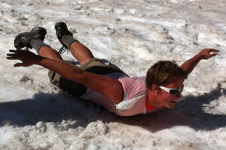 Caleb Krumseig, junior, slides down the snow during the Montana Summer Seminar group’s spontaneous sledding adventure. The students used trash bags, Crazy Creek chairs and their stomachs to aided them in their descent. Photo by: Scott Vonder Bruegge