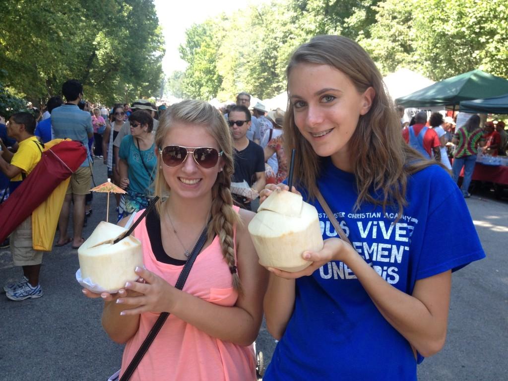 Audrey ONeill, sophomore, and Kirsten Caplinger, junior, sip coconut water purchased from a Thai booth.