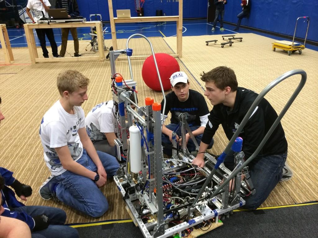 Matthew Hoekzema, freshman, Brennan Murphy, sophomore, and Alex Kessel, junior, work on this years robot.