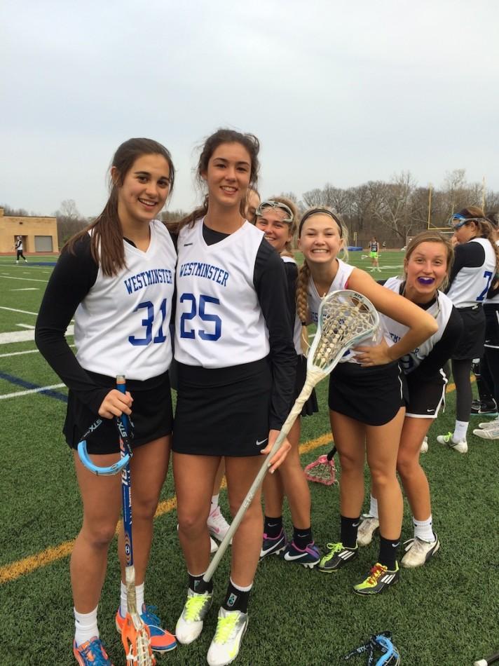 Varsity lacrosse players pose for a picture in the excitement of their win.