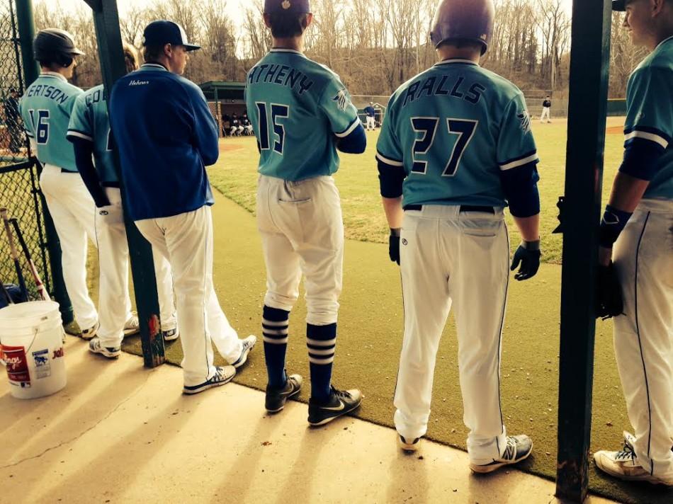 The baseball team watches from the dugout.