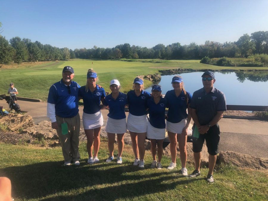 The girls golf team smiles for a picture after a match.