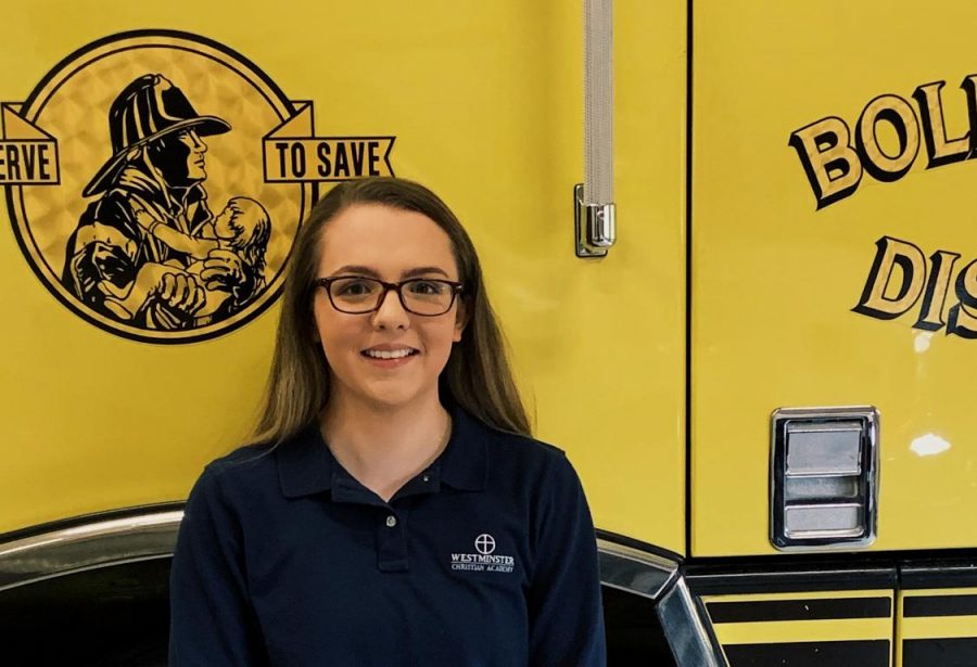 Hannah Carter stands with a firetruck from the Boles Fire Protection District.