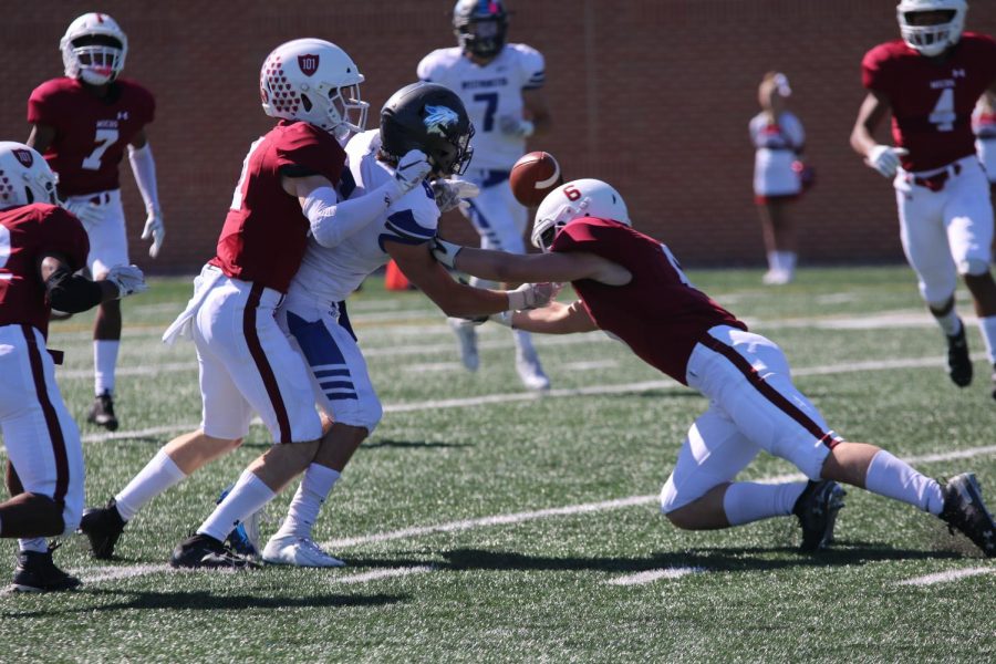 Ben Straub tips the ball into the air as he is hit by two MICDS defenders in a game on Saturday, October 12.