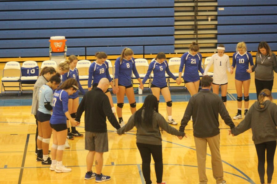 The girls volleyball team gathers in prayer with their opponents after a match against St. Dominic High School on Oct. 23, 2019.