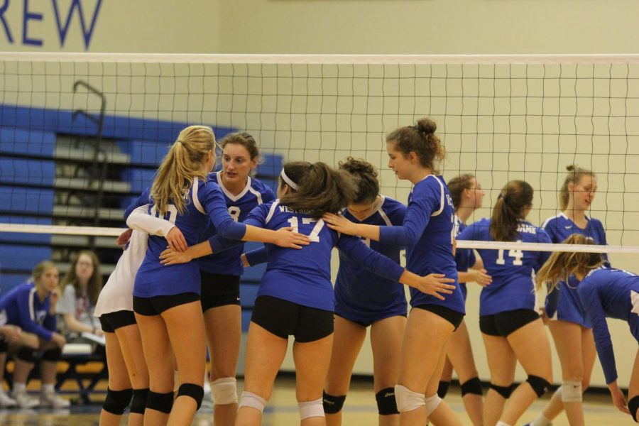 The team huddles together after a point in a regular season match.