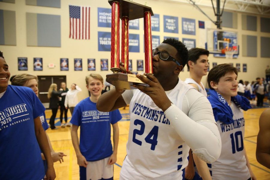 Senior Bennie Anderson kisses the Town and Country Cup. The Cup will remain at Westminster.