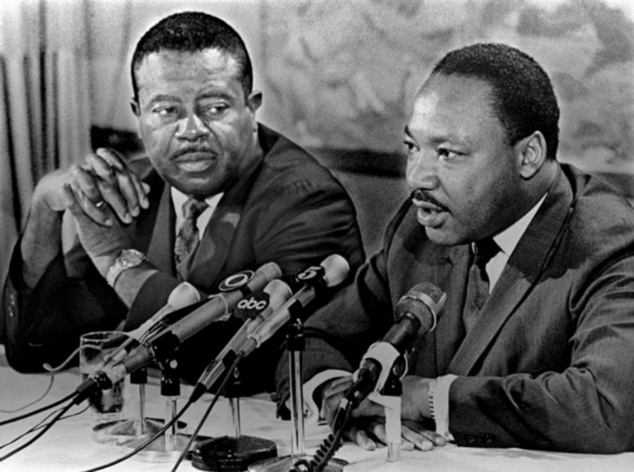 Ralph Abernathy listening to Dr. King as he gives a speech. 