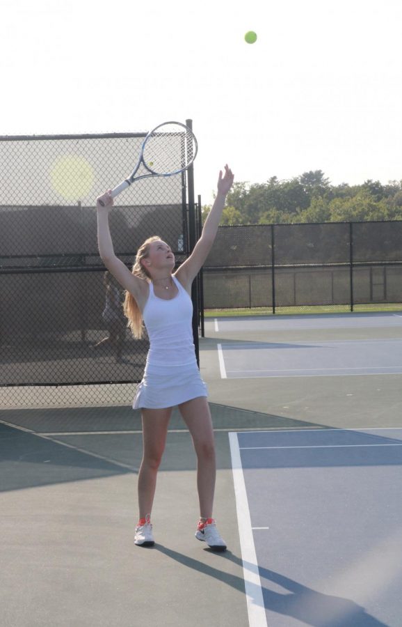 Hailey Colley tosses the ball in the air to serve.