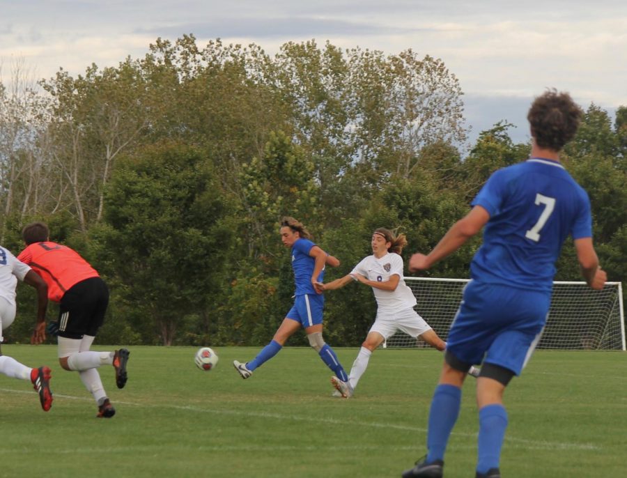 Jackson Keane, junior, holds off the defender, shoots, and scores.