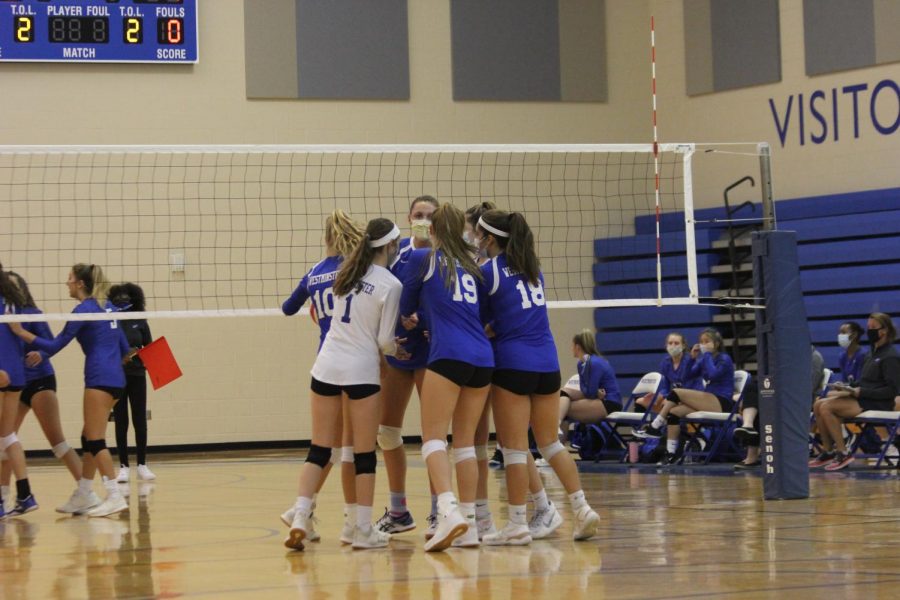 The girls gather in a huddle after winning a point.