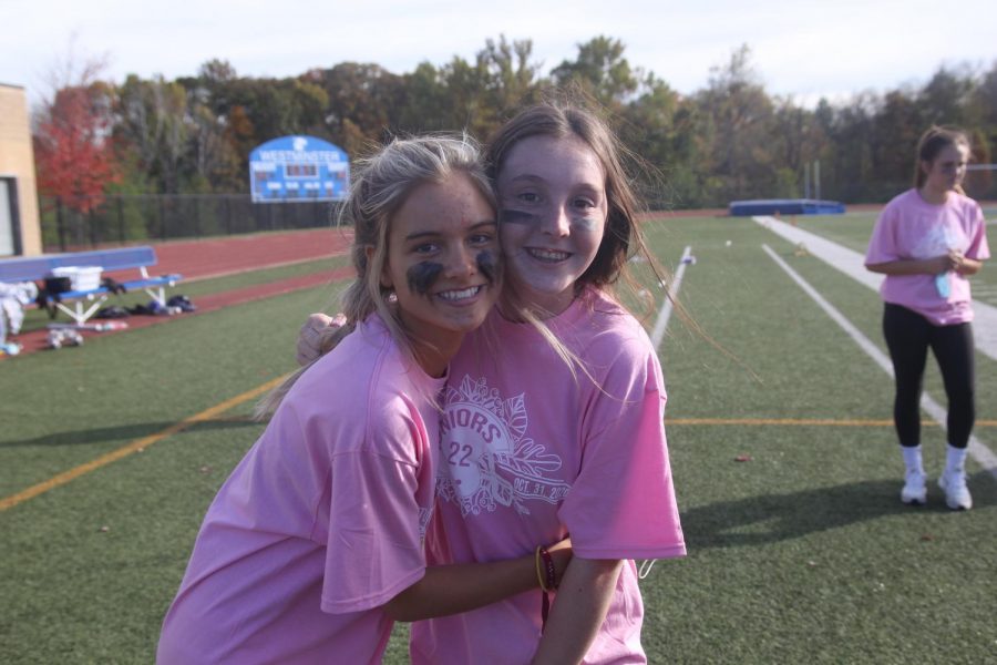 two juniors posing on the sidelines of the junior senior powderpuff game. 