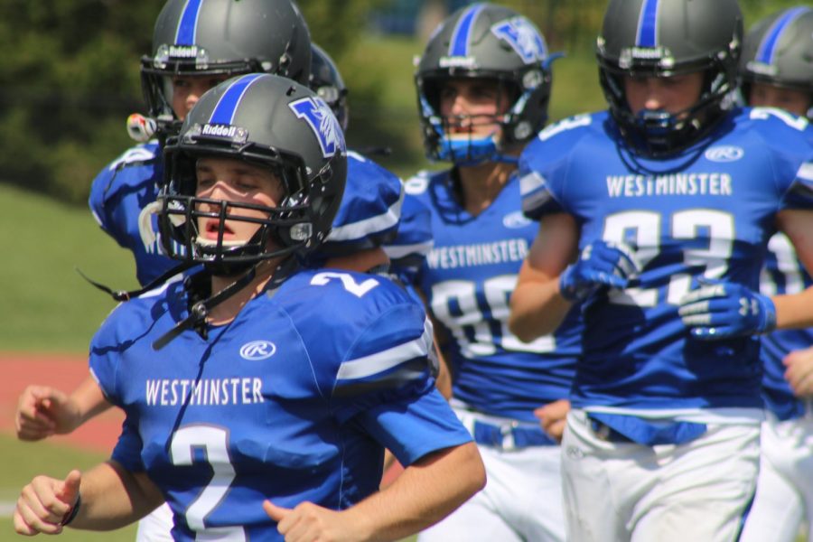 The football team running onto the field at the beginning of the game. 