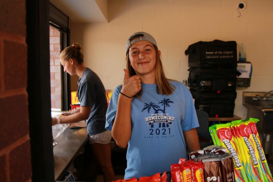 one of he food booth workers gives a thumbs up for how the carnival is going. 