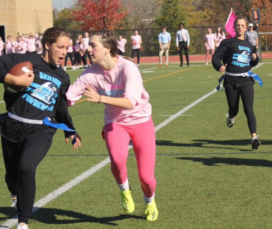 Kate Dempsey senior runs the ball as Sara Schloss attempts to stop her. 