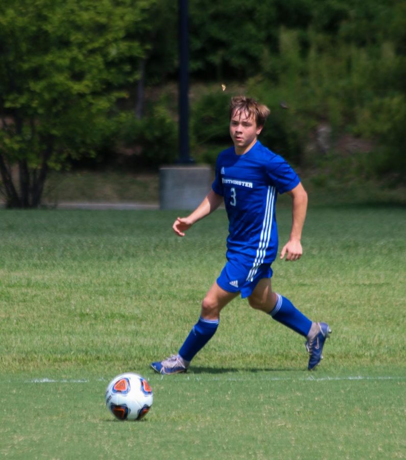 Caden Collison dribbles the ball up the field against MICDS.