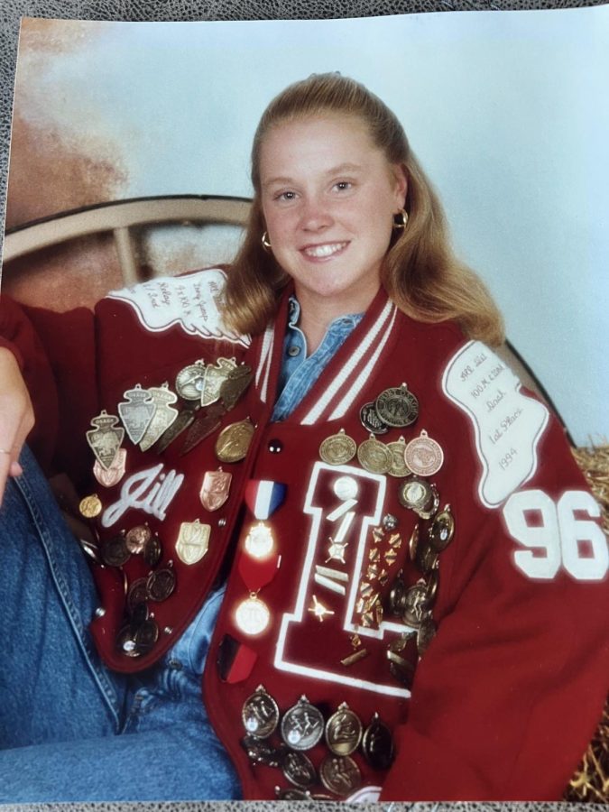 Jill Schuelens senior picture with her medaled jacket.