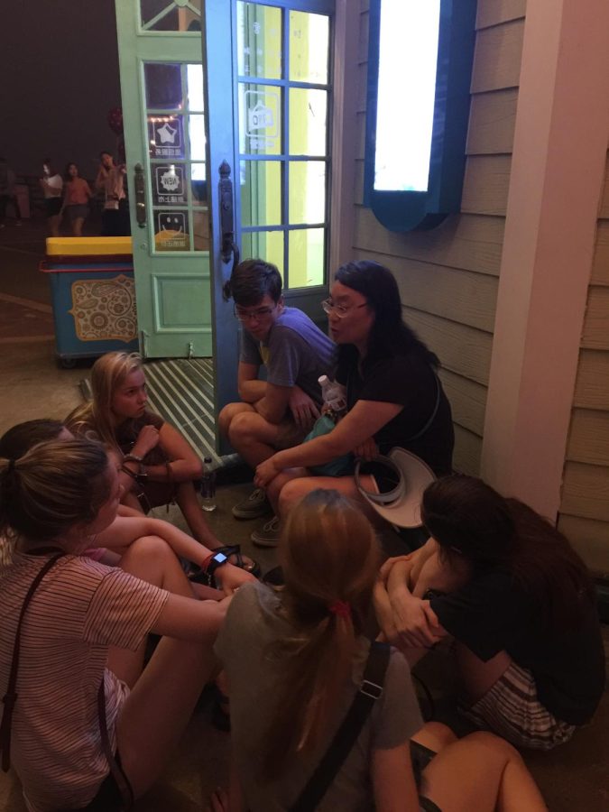 Dr. Li's students gathered around her at a theme park in China to listen to her life story.
