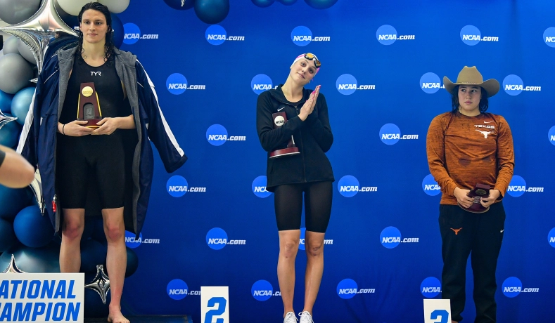 Penn swimmer, who is a biological man, holds a trophy after winning the 500m freestyle event.