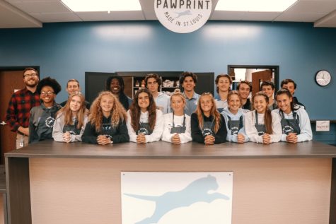 The Pawprint team gathers in front of their storefront in the academic hub.