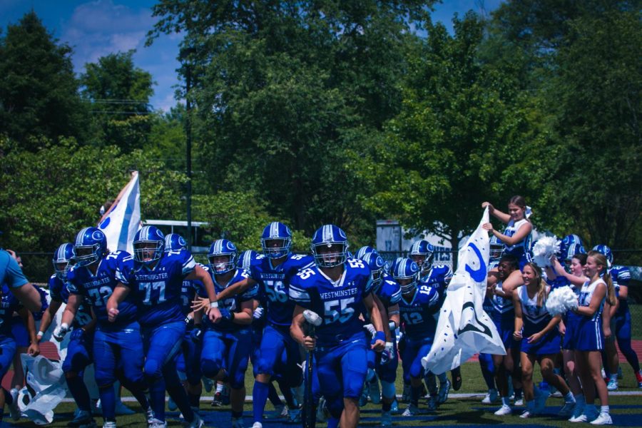The football team charges the field.