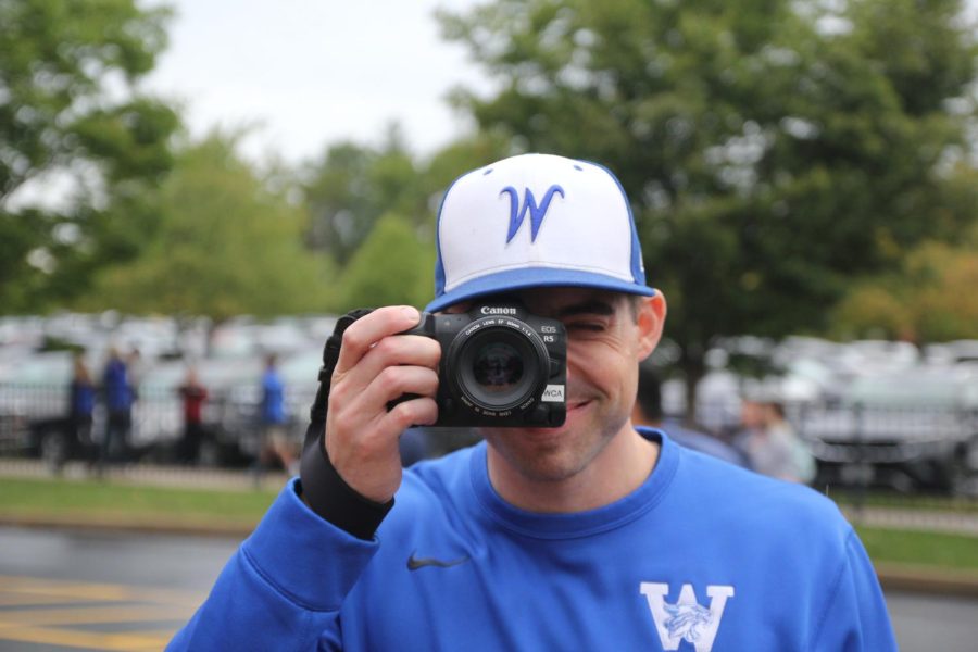 A teacher takes photos of the carnival festivities.