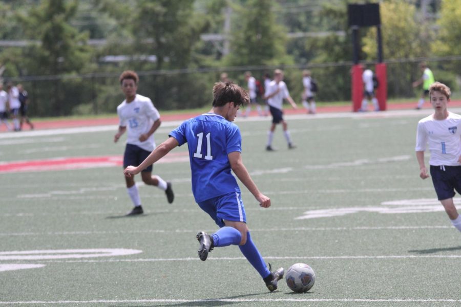 A wildcat soccer player bombs the ball.