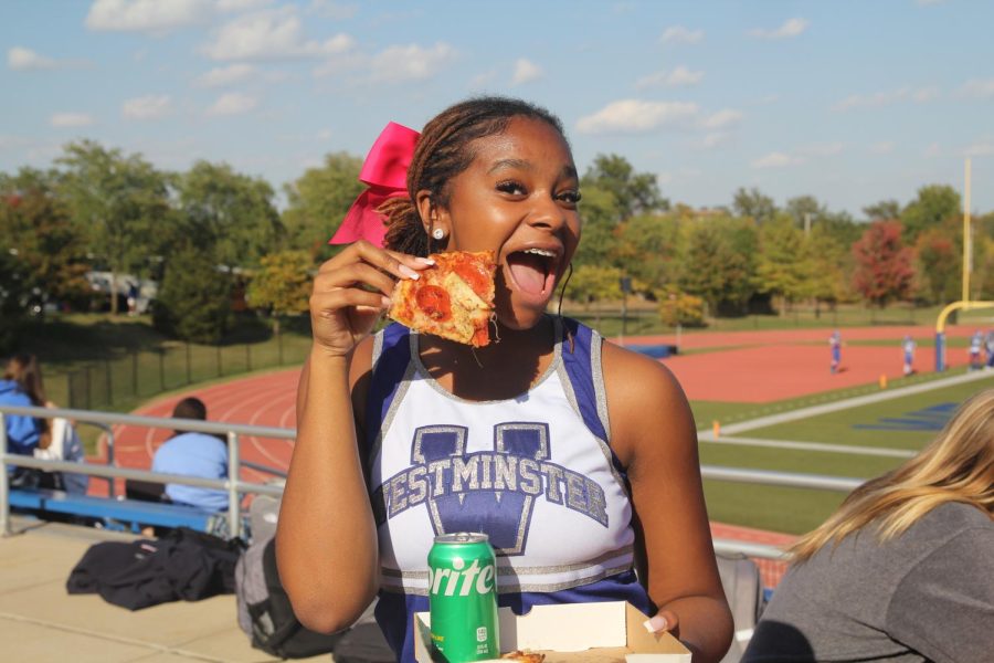 Alijah Hunter poses excitedly with her slice of pizza.