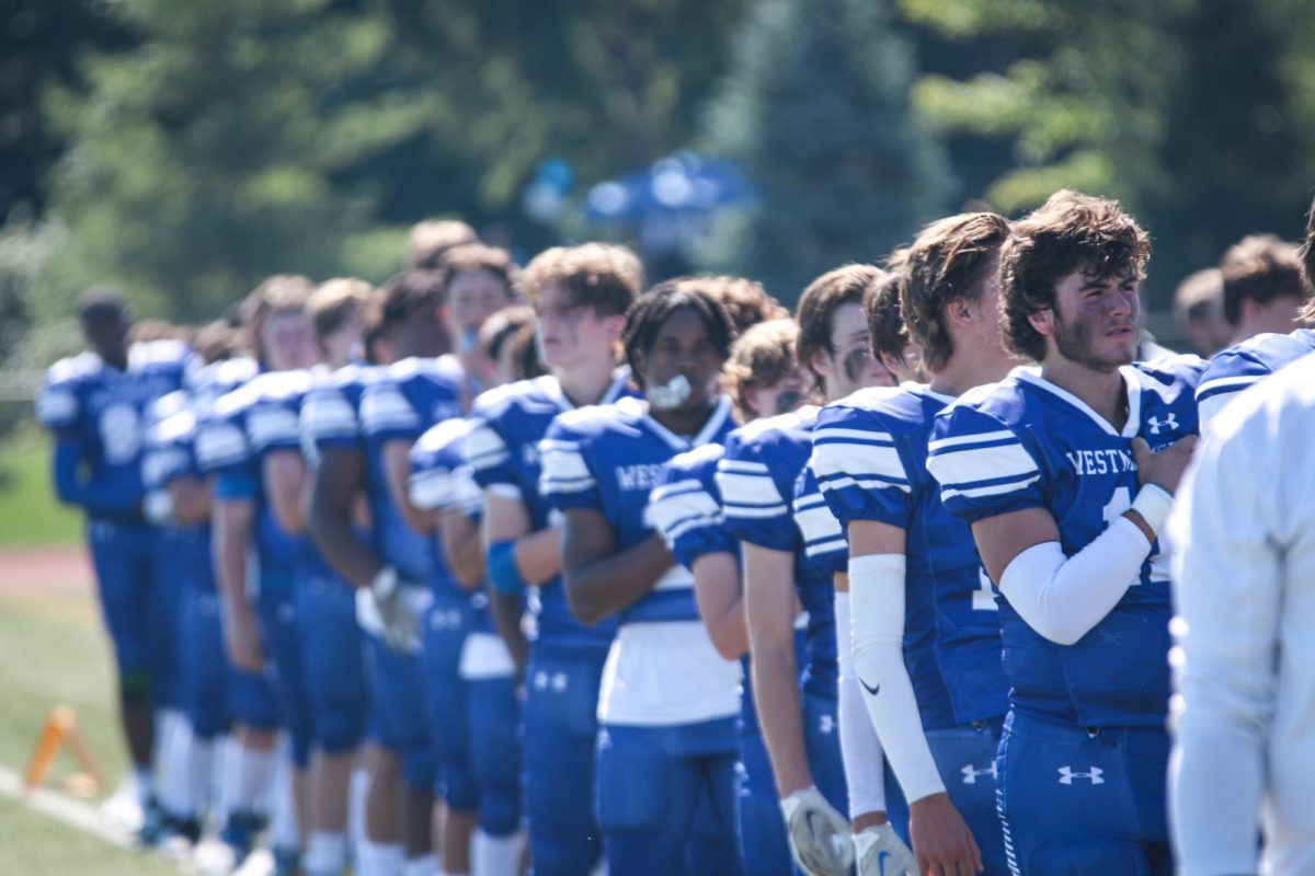 football team lines up for the National Anthem at the 2022 season home opener