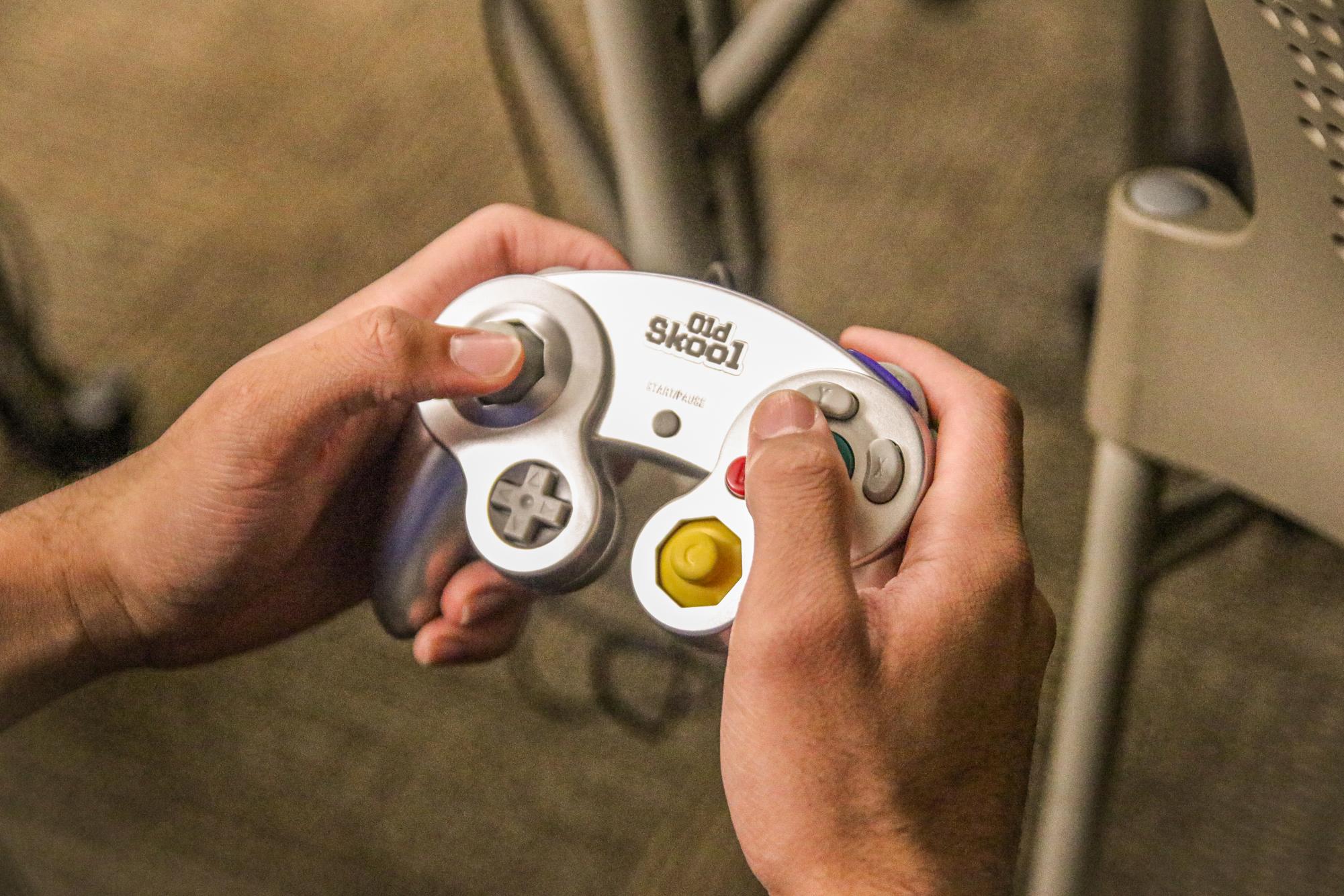 A smash club member holds up an Old Skool controller.