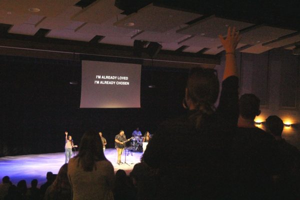 People stand worship in the Theatre.