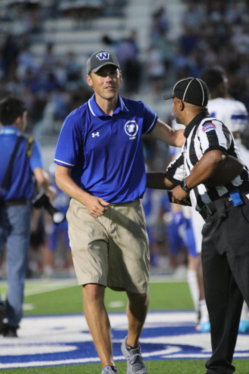 coach Snyder walking back to the sideline after the pre-game meeting with the referees