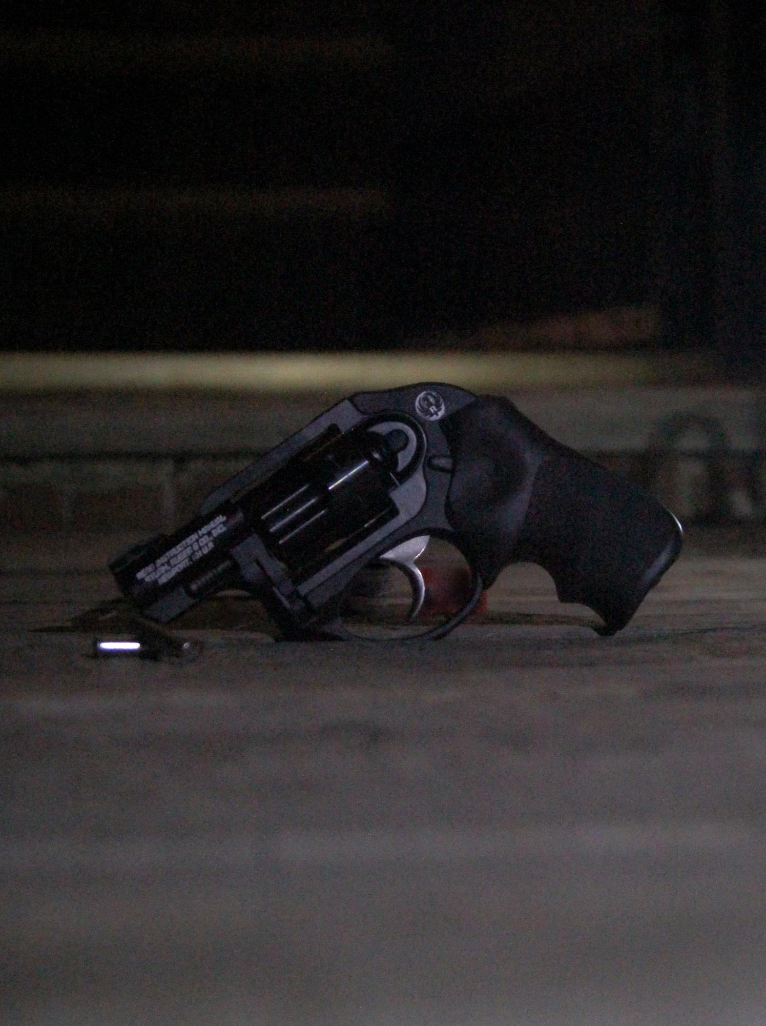 A gun rests on a planked floor.