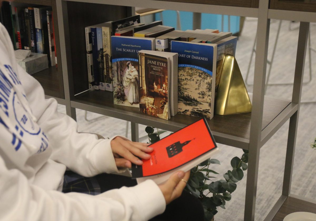 Image of a girl reading "The Crucible" surrounded by other controversial books such as "Heart of Darkness" 