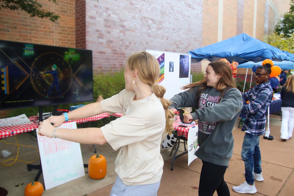 Two girls having fun while following the dancer on the Just Dance game.