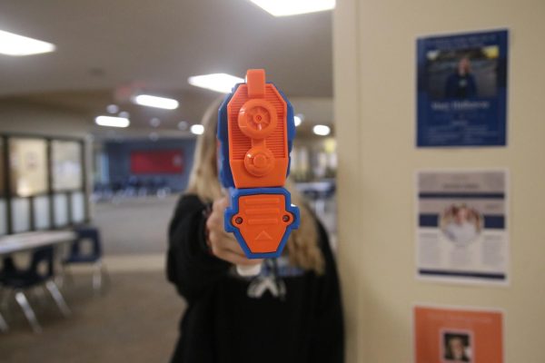 A senior pointing a water gun at the camera