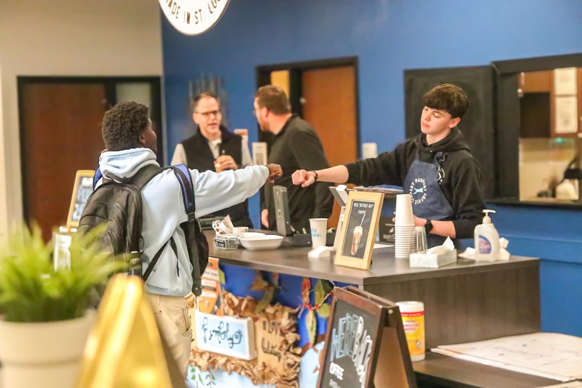 Senior Caden Seilback fist-bumps a classmate before taking his order on opening day.