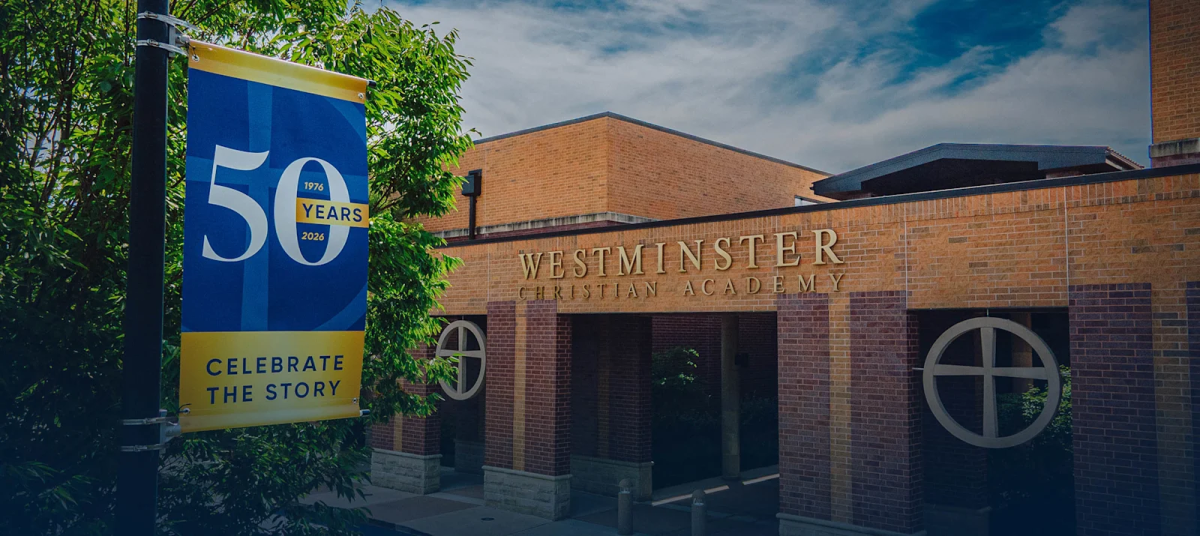 The Westminster Christian Academy building with a 50th anniversary flag on a pole by a tree.